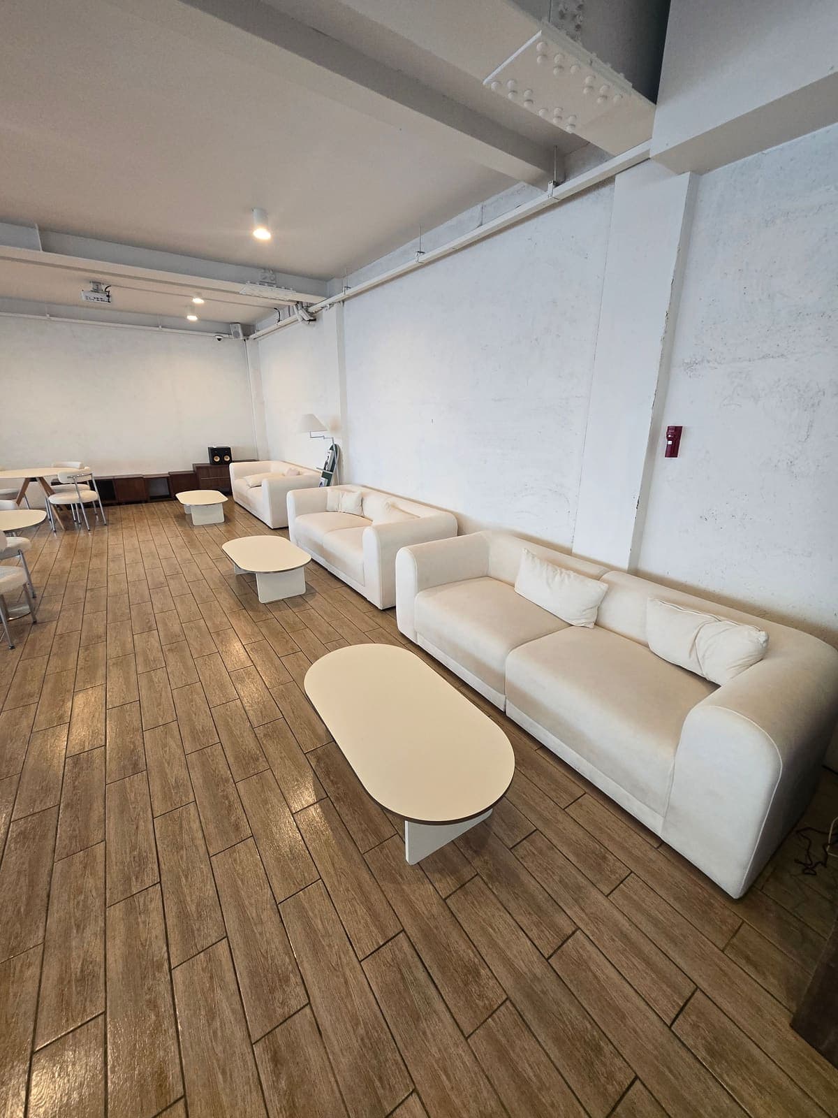 청설모 토탈케어 카페 청소 완료, 흰 소파가 놓인 라운지 바닥